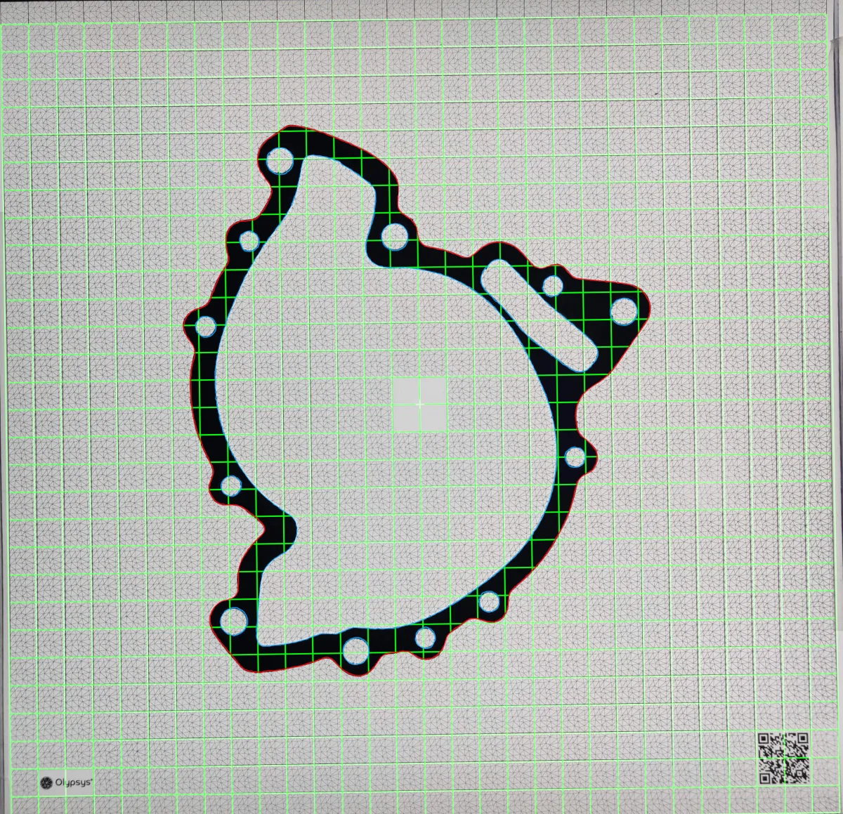 Phone photo of a transmission housing gasket on an Olypsys grid, with the AI segmentation overlaid